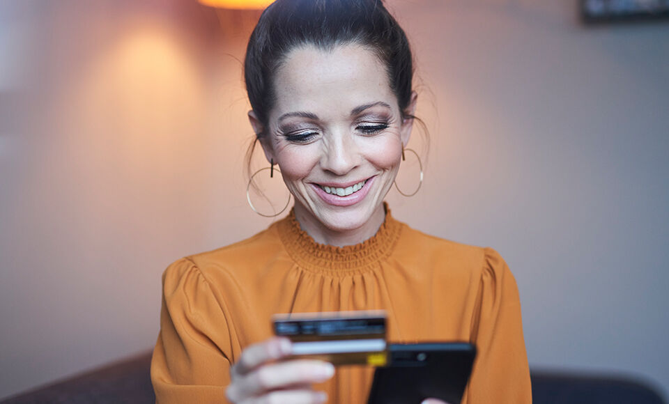 femme sur son smartphone avec carte bancaire